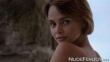 A stunning short-haired woman shows off her shaved pussy outside.