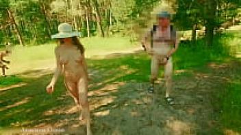 A nudist female strolls among others in clothing in a woodland close to the beach. (Ocean Emerald)