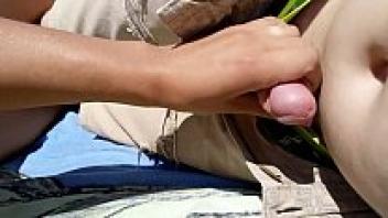 On a public beach, a girl masturbates her partner.